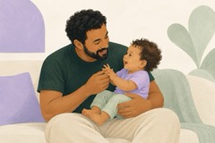 Pai segura o bebê com apoio e conversa olhando para ele.